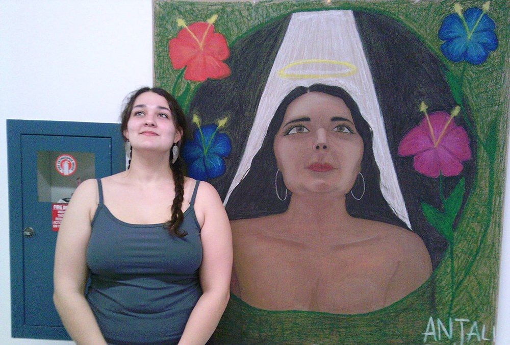 Anjali Denissov standing beside her self-portrait